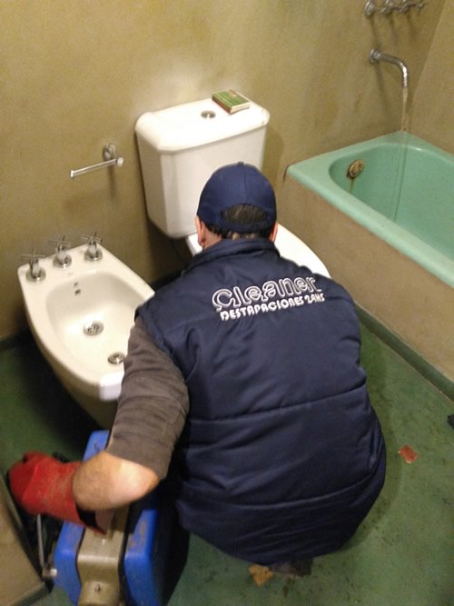 Técnico de Cleaner Destapaciones trabajando en un baño con máquina profesional